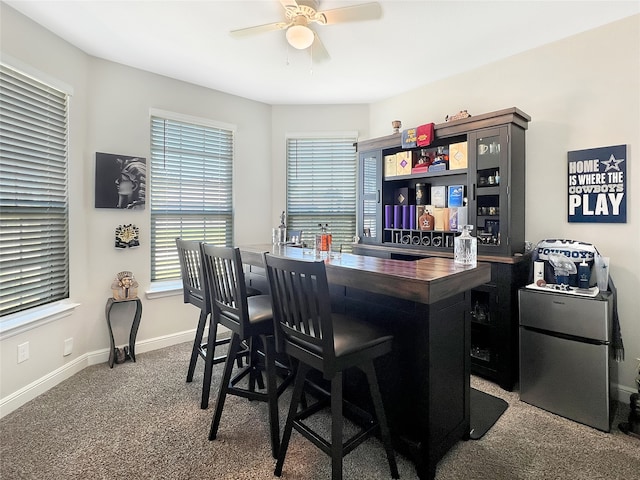 bar featuring carpet floors, stainless steel fridge, wood counters, and ceiling fan