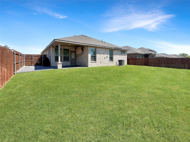 back of house featuring cooling unit, a patio area, and a yard