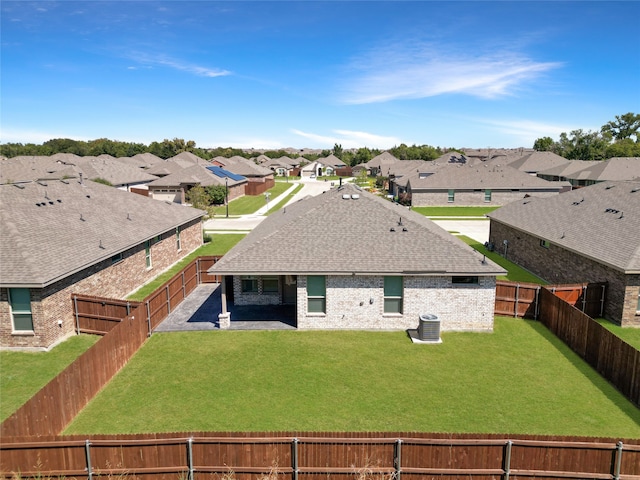 back of house with a patio, a lawn, and central AC