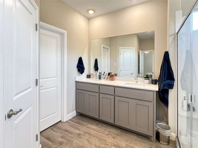 bathroom with vanity, hardwood / wood-style floors, and a shower with shower door