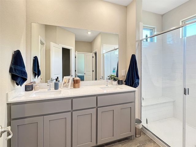 bathroom with a shower with door, vanity, and hardwood / wood-style flooring