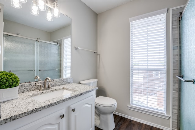 bathroom with vanity, wood-type flooring, walk in shower, an inviting chandelier, and toilet