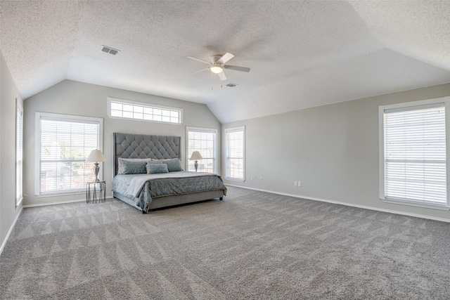 unfurnished bedroom with multiple windows, lofted ceiling, ceiling fan, and light colored carpet