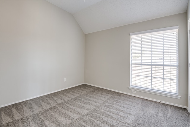 empty room featuring lofted ceiling and carpet flooring