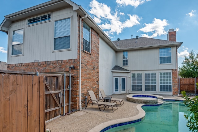 back of house with a pool with hot tub and a patio