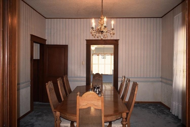 carpeted dining room with a notable chandelier, a textured ceiling, wallpapered walls, and ornamental molding