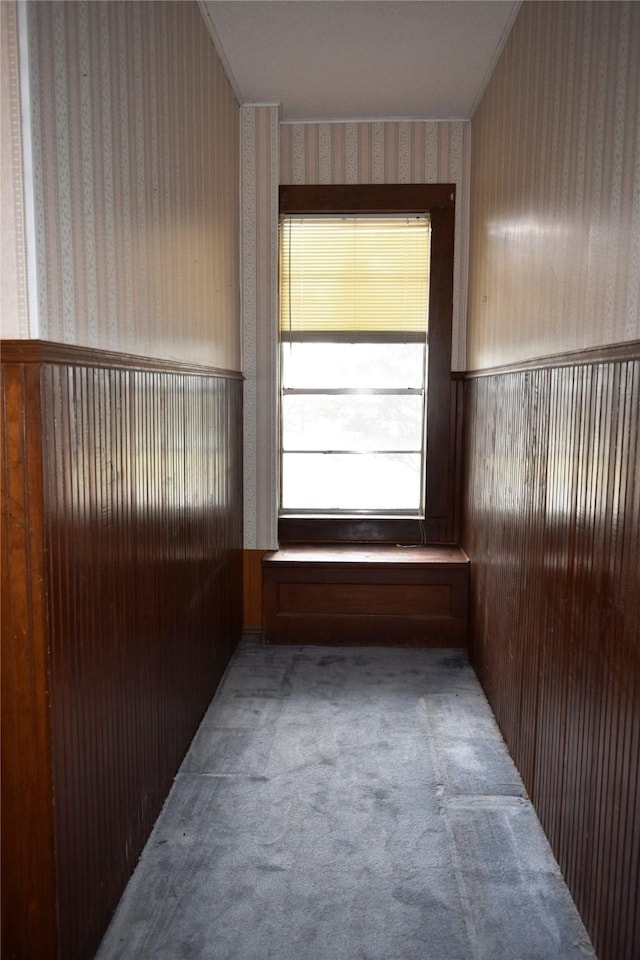 carpeted empty room with wainscoting and wallpapered walls