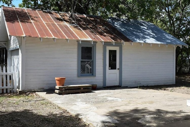 rear view of house featuring a patio area and metal roof