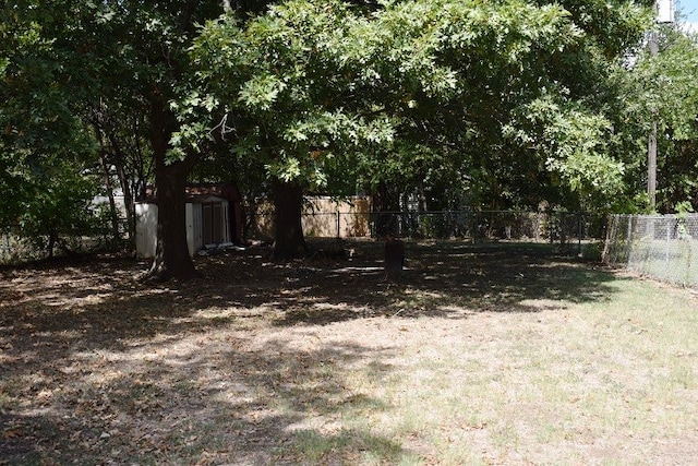 view of yard with an outbuilding, a storage shed, and fence