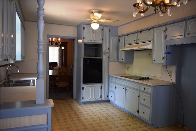 kitchen with under cabinet range hood, light countertops, ceiling fan with notable chandelier, black appliances, and a sink