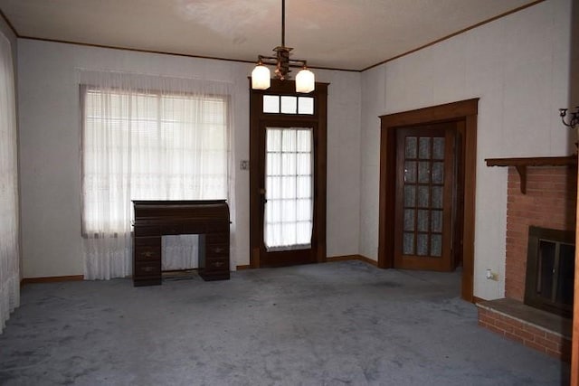 unfurnished living room with carpet, a fireplace, a chandelier, and ornamental molding