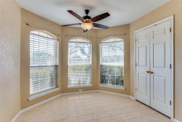 empty room with a wealth of natural light and ceiling fan