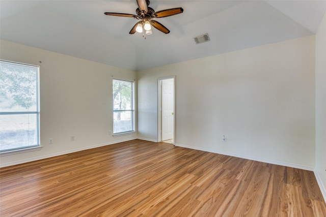 unfurnished room featuring plenty of natural light, light hardwood / wood-style floors, and vaulted ceiling