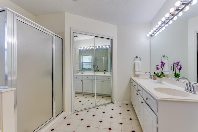 bathroom featuring a shower with door and vanity