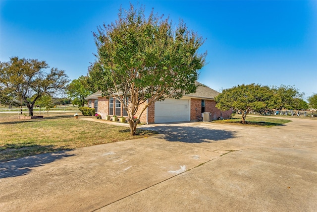 view of front of property with a front yard, central AC, and a garage