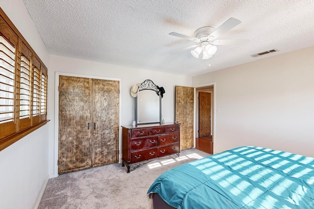 carpeted bedroom featuring a closet, ceiling fan, and a textured ceiling