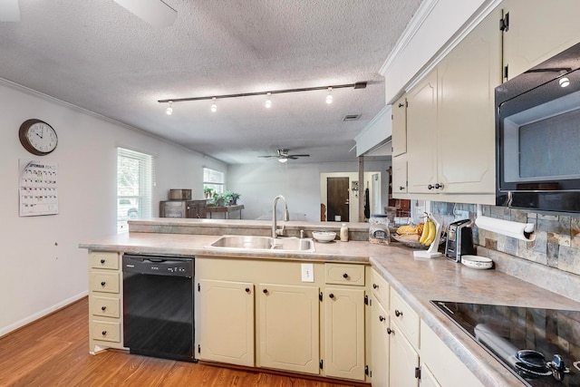 kitchen with ceiling fan, sink, a textured ceiling, black appliances, and light hardwood / wood-style floors