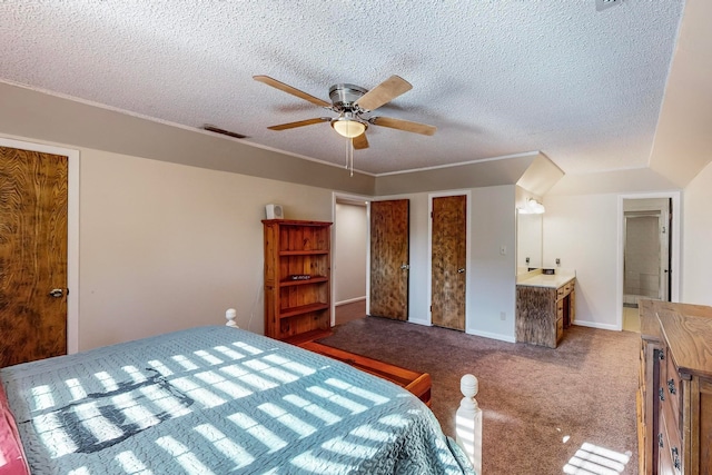 bedroom with a textured ceiling, ensuite bath, ceiling fan, and carpet floors