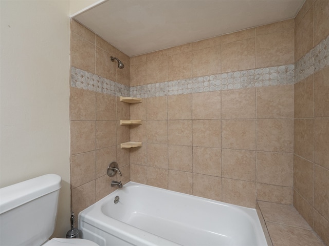 bathroom featuring tiled shower / bath and toilet