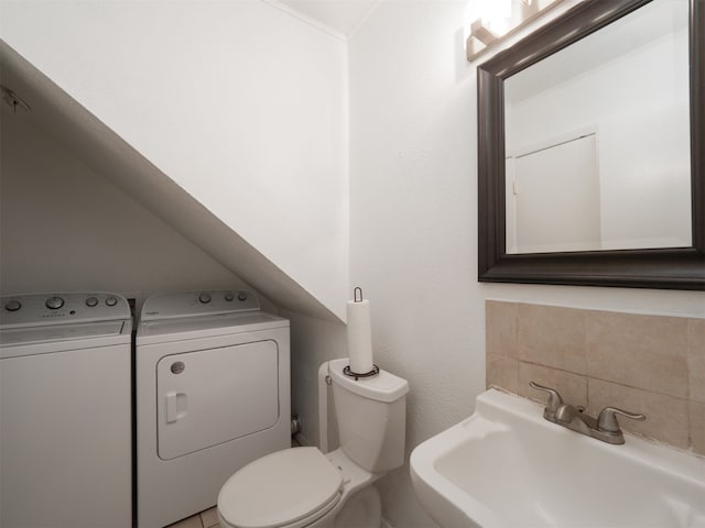 bathroom featuring washer and clothes dryer, toilet, and sink