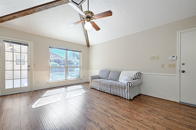 living room featuring vaulted ceiling with beams, a textured ceiling, and hardwood / wood-style flooring