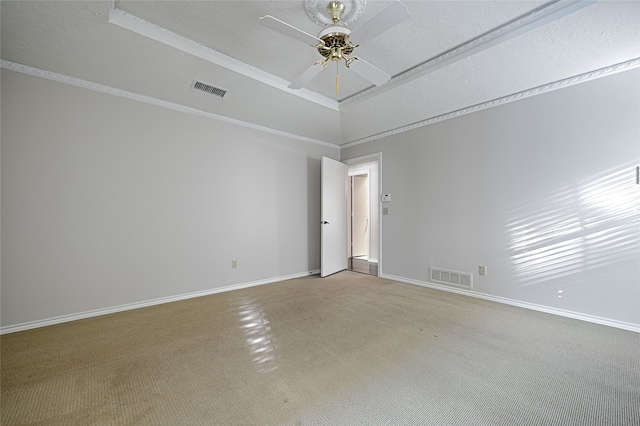 carpeted spare room with ceiling fan, crown molding, and a textured ceiling