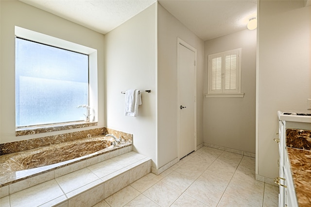 bathroom with vanity, tiled bath, tile patterned floors, and a textured ceiling