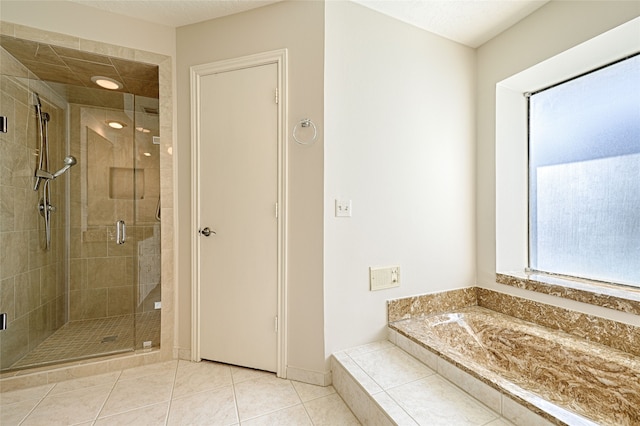 bathroom with a textured ceiling, shower with separate bathtub, and tile patterned flooring