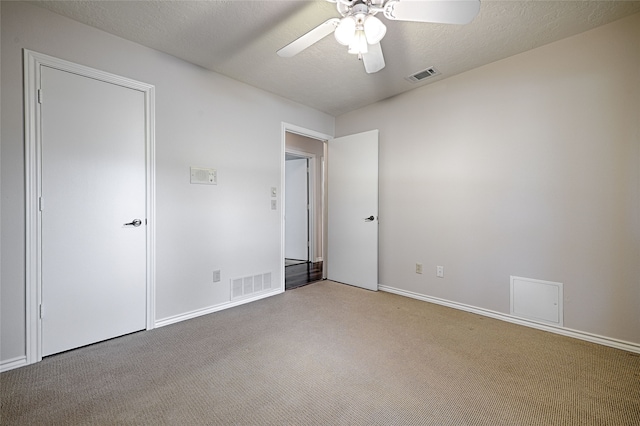 spare room featuring carpet flooring, a textured ceiling, and ceiling fan