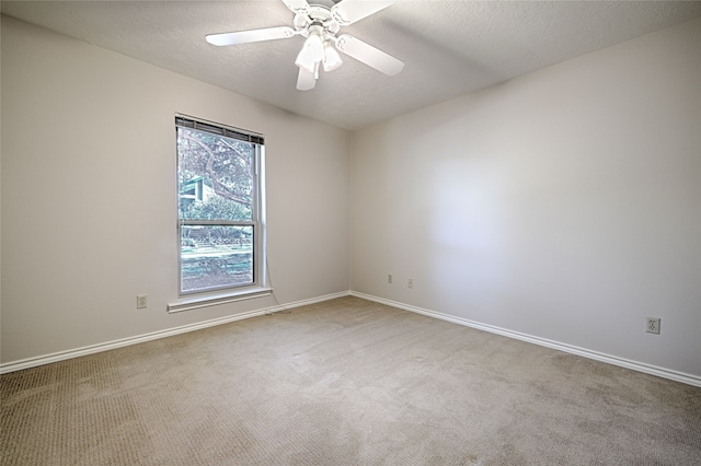 carpeted spare room with a textured ceiling and ceiling fan