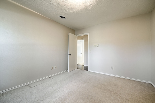 carpeted spare room featuring a textured ceiling