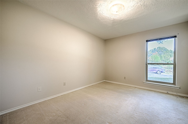 carpeted empty room with a textured ceiling