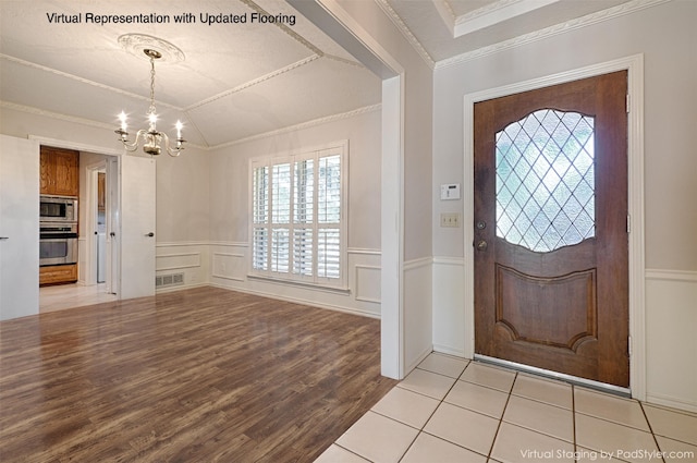 entrance foyer featuring light hardwood / wood-style floors, crown molding, a textured ceiling, and an inviting chandelier