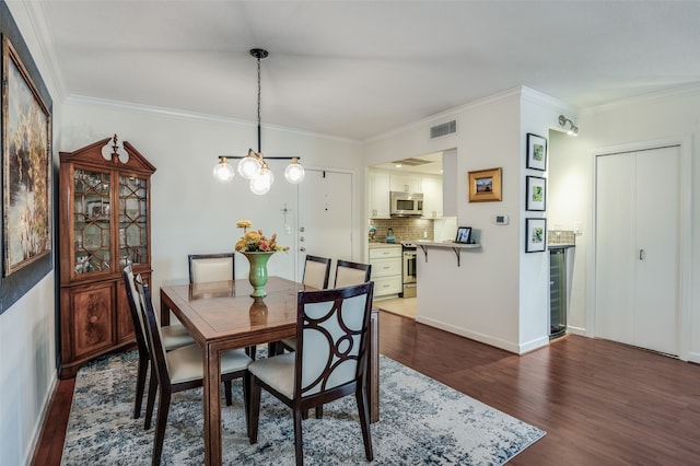 dining space featuring an inviting chandelier, ornamental molding, and dark hardwood / wood-style flooring