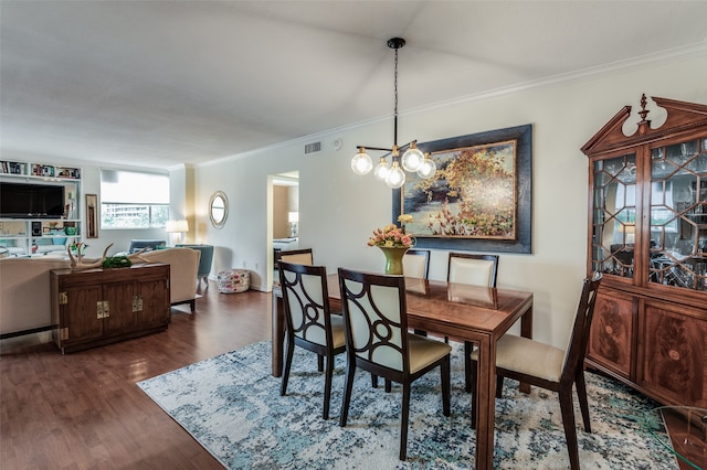 dining area with an inviting chandelier, ornamental molding, and dark hardwood / wood-style flooring