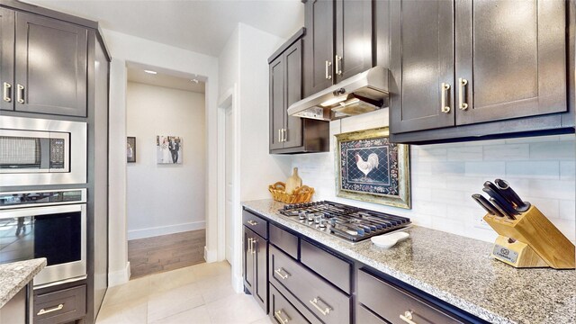 kitchen featuring light stone counters, appliances with stainless steel finishes, sink, and a wealth of natural light