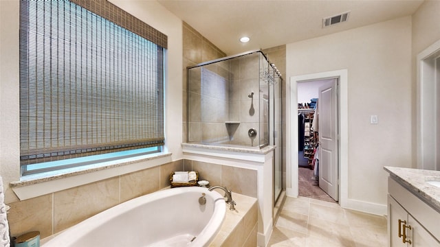 bathroom featuring shower with separate bathtub, vanity, and tile patterned floors