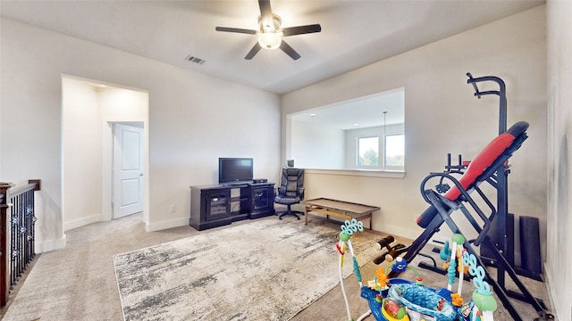 workout area featuring ceiling fan and light carpet