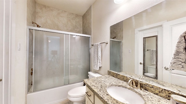 full bathroom with shower / bath combination with glass door, vanity, and toilet