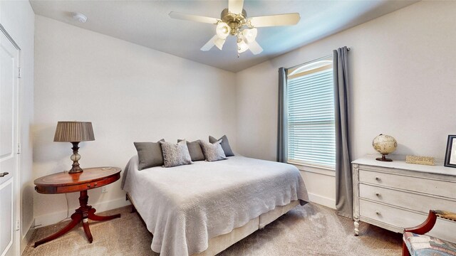 carpeted bedroom with ceiling fan and multiple windows