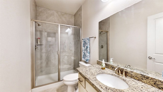 bathroom with vanity, a shower with shower door, toilet, and tile patterned flooring