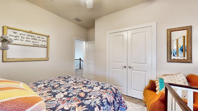 bedroom with ceiling fan, light colored carpet, and a closet