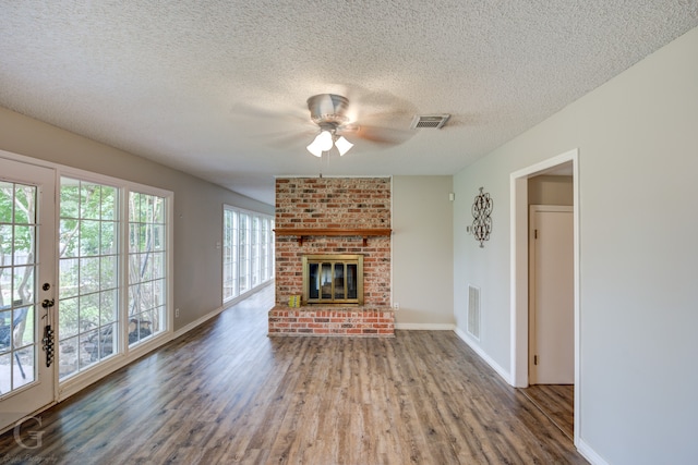 unfurnished living room featuring a textured ceiling, a fireplace, ceiling fan, and hardwood / wood-style flooring