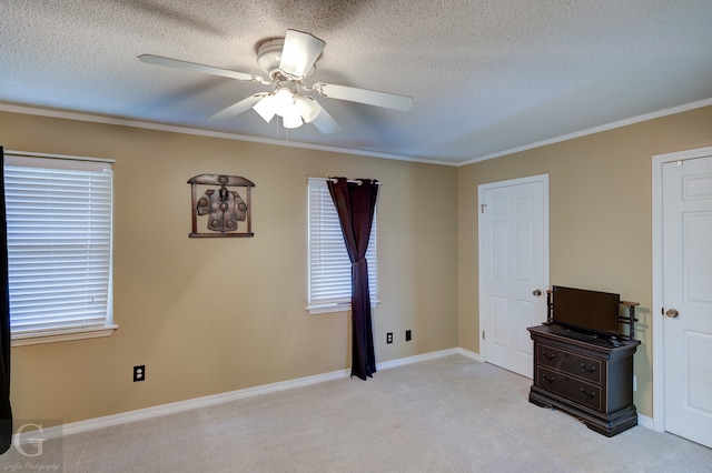 interior space with a textured ceiling, ceiling fan, light colored carpet, and plenty of natural light