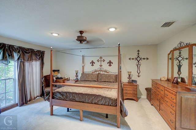 bedroom with a textured ceiling, ceiling fan, and light colored carpet