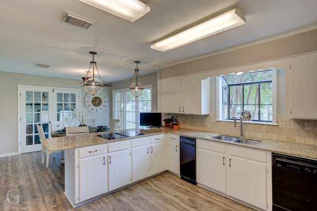 kitchen with sink, kitchen peninsula, white cabinetry, black appliances, and light hardwood / wood-style floors