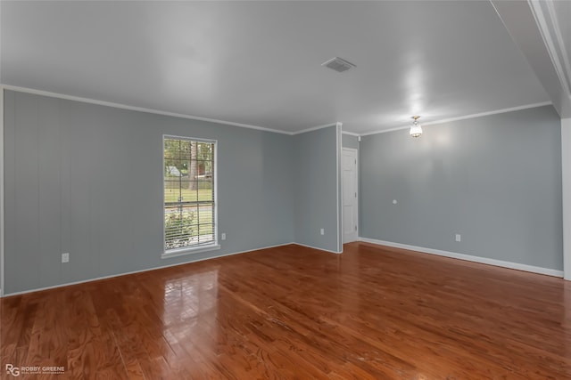 spare room with wood-type flooring and ornamental molding