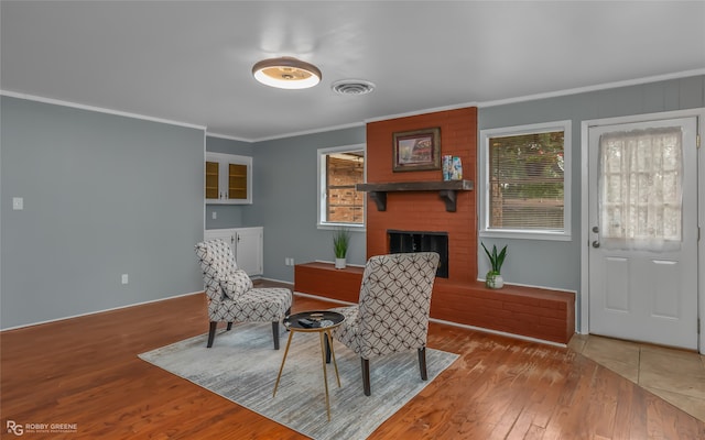 dining area featuring hardwood / wood-style flooring, a fireplace, and crown molding