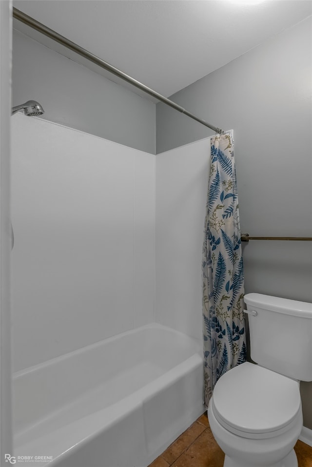 bathroom with tile patterned floors, shower / tub combo, and toilet