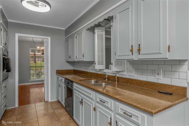 kitchen with black dishwasher, sink, an inviting chandelier, light tile patterned floors, and crown molding